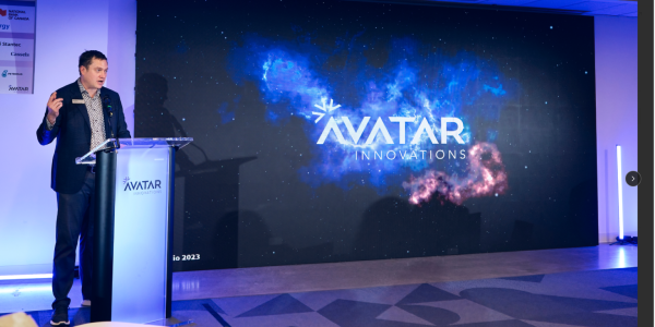 Kevin Krausert, Avatar CEO & Co-founder, presenting in front of a podium on the Avatar program with a presentation screen behind 